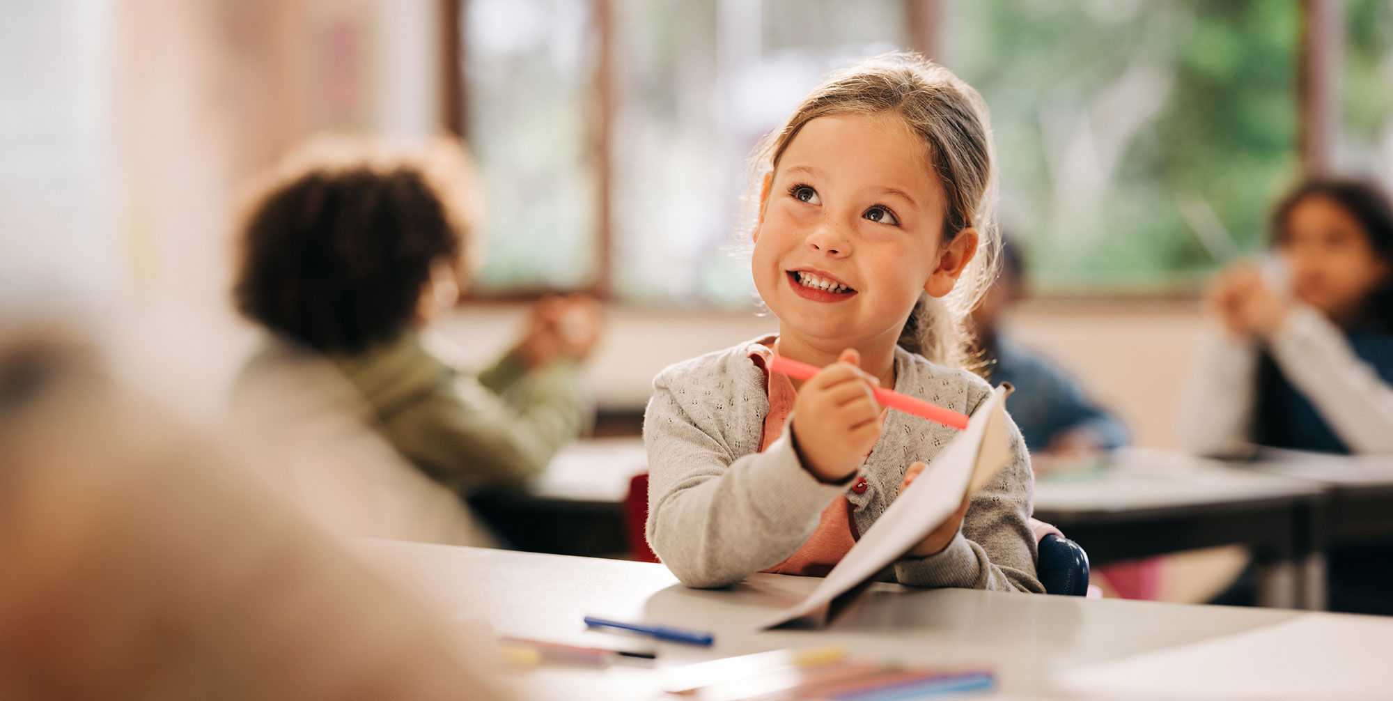 Child writing and reading at Funky Nursery & Pre-School in Cheltenham