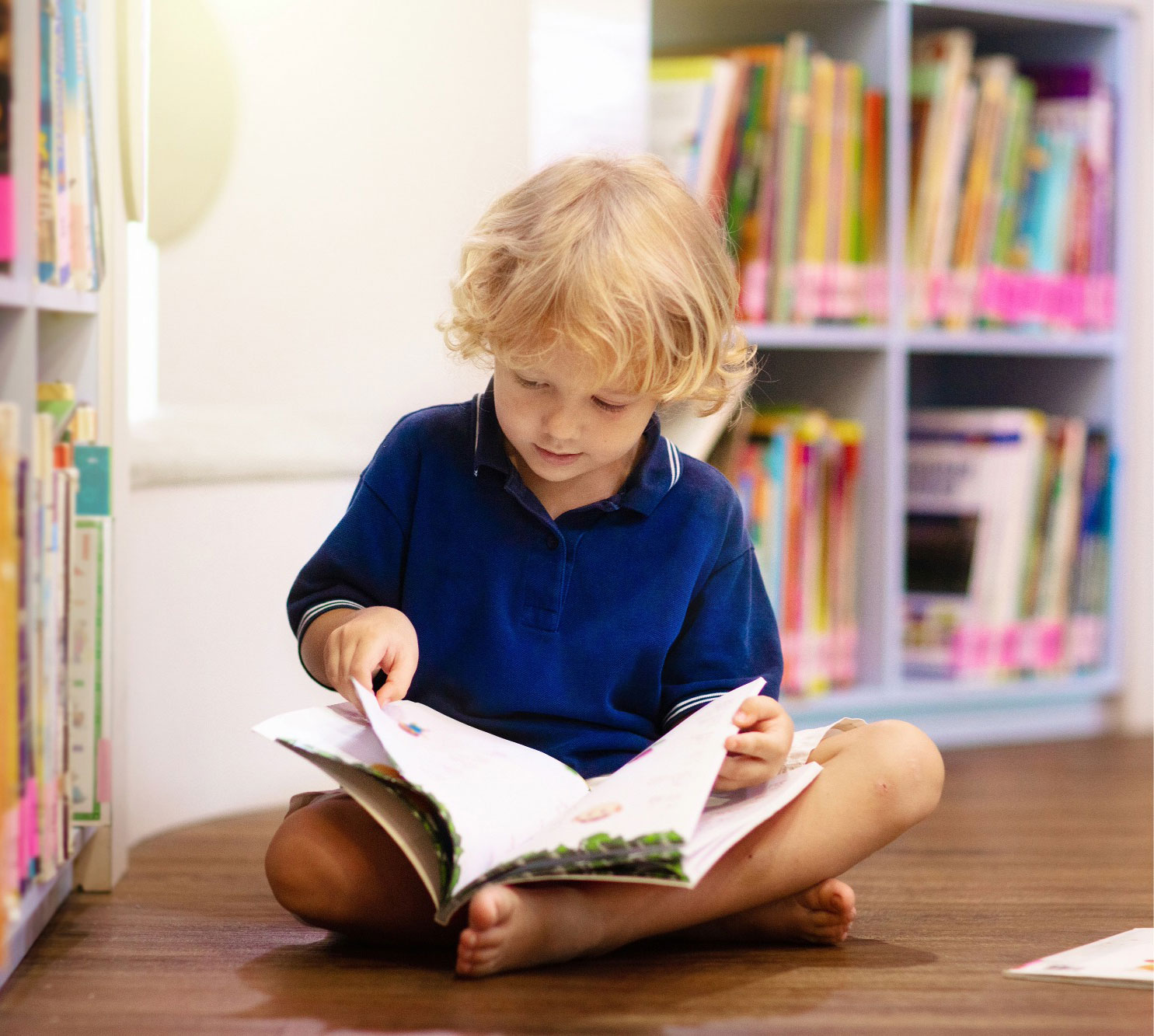 Child reading independently on floor at Funky Nursery in Cheltenham