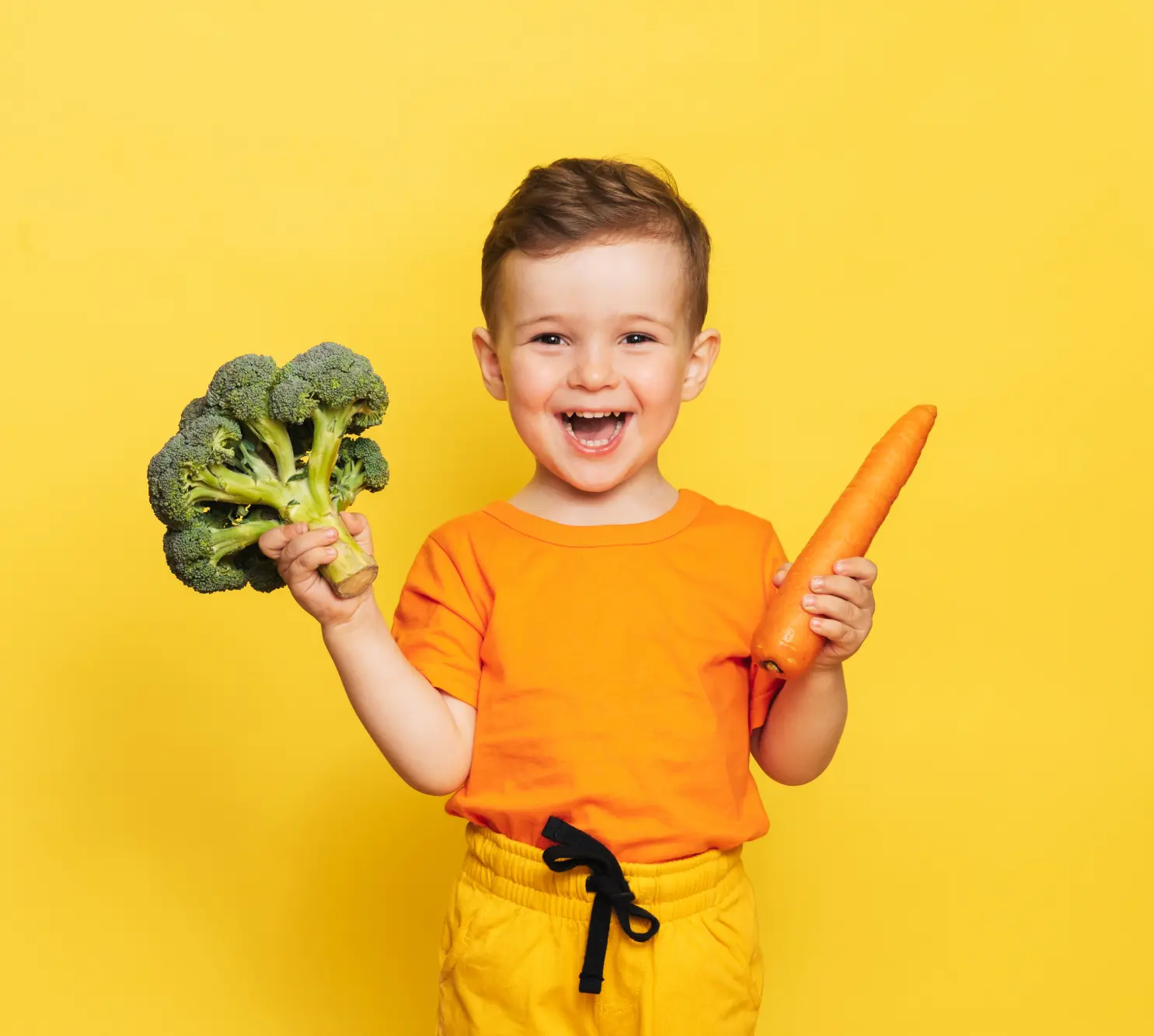 Young child holding fresh vegetables representing healthy eating at Funky Nursery in Cheltenham